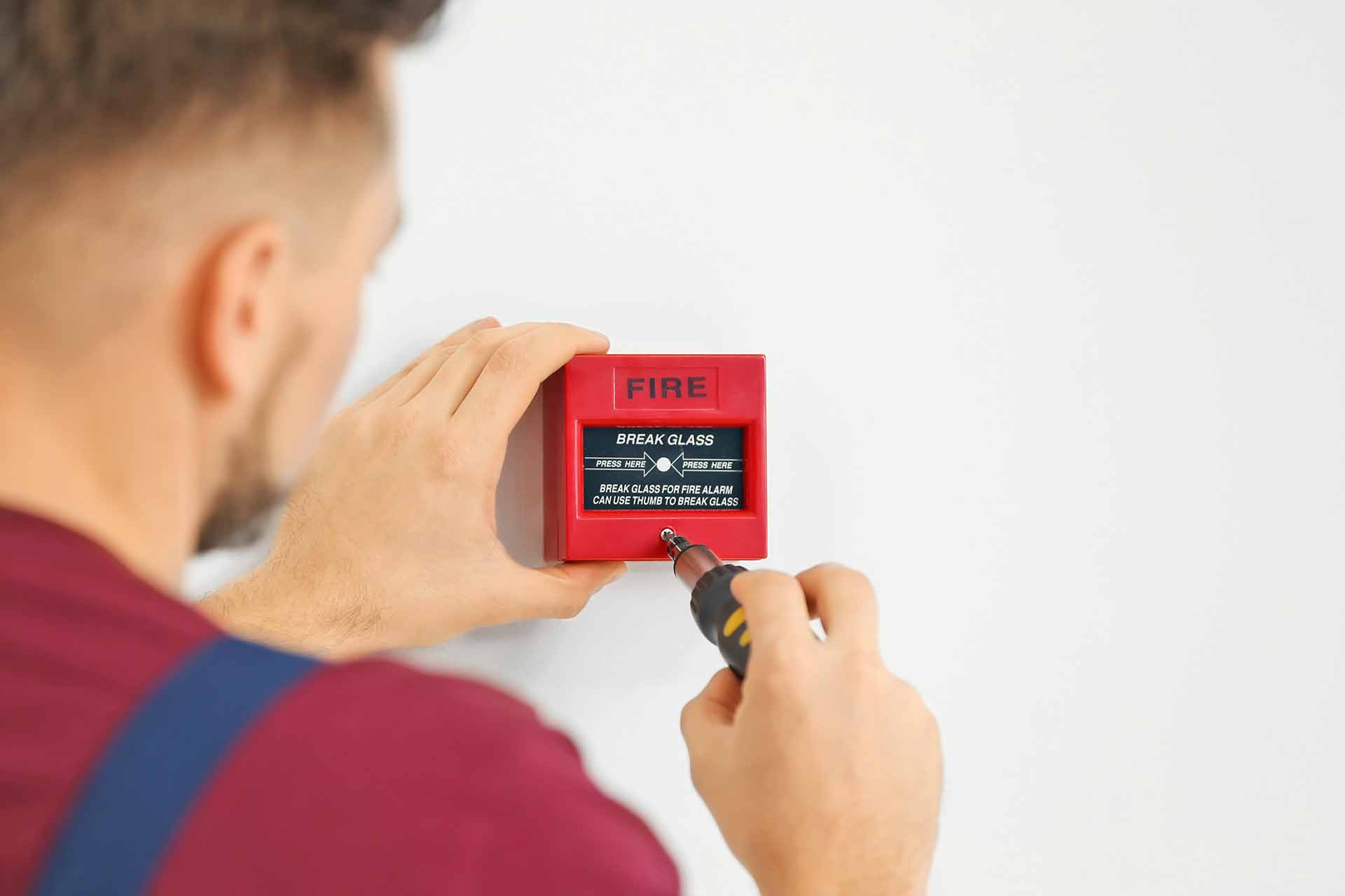 fire alarm engineer with fire alarm break glass